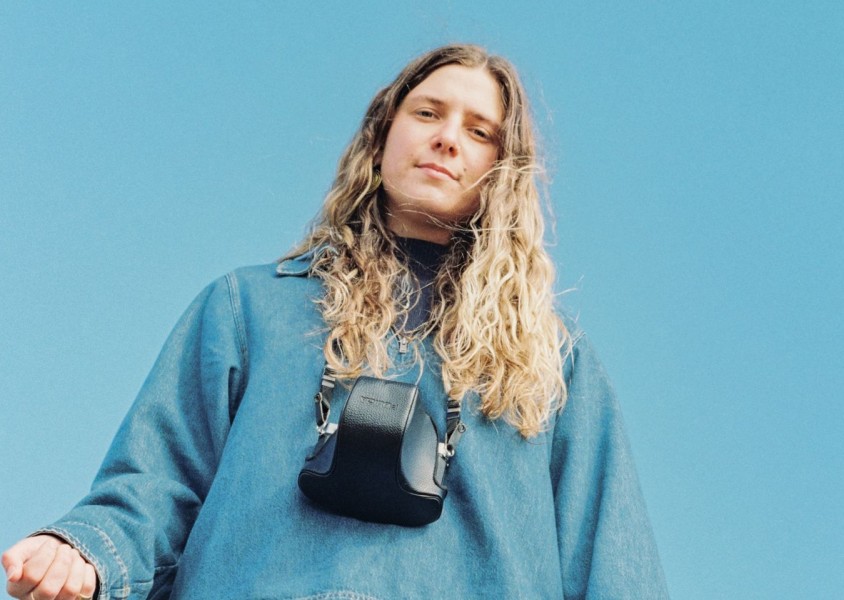 Rosie H Sullivan in a denim jacket with a camera around her neckx